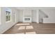 Well-lit living room with hardwood floors, a fireplace, and a door to an outside deck at 1035 Zelkova Ln, Chapel Hill, NC 27517