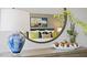 Bedroom decor shown in mirror's reflection with decorative lamp, flowers, fruit bowl, and colorful art at 106 Craig Point Dr, Clayton, NC 27520