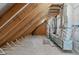 Spacious unfinished attic featuring exposed beams, wooden supports, insulation, and HVAC ducts at 116 Pointe Park Cir, Holly Springs, NC 27540