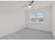 Spacious, carpeted bedroom showcasing a ceiling fan and a large window for plenty of natural light at 116 Pointe Park Cir, Holly Springs, NC 27540