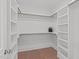 Spacious walk-in closet featuring custom shelves and wood flooring at 116 Pointe Park Cir, Holly Springs, NC 27540
