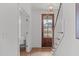 Bright foyer showcasing a wood door with glass, hardwood floors, staircase, and a modern light fixture at 116 Pointe Park Cir, Holly Springs, NC 27540