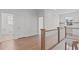 Upstairs hallway with hardwood floors and natural light at 116 Pointe Park Cir, Holly Springs, NC 27540