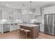 Modern kitchen features an island, pendant lights, stainless steel appliances, and hardwood floors at 116 Pointe Park Cir, Holly Springs, NC 27540