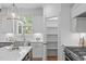 Well-lit kitchen showing a pantry, stainless steel sink, and custom white cabinets at 116 Pointe Park Cir, Holly Springs, NC 27540