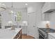 Bright kitchen with an island, a stainless steel sink and appliances, and custom white cabinetry at 116 Pointe Park Cir, Holly Springs, NC 27540