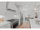 Modern kitchen featuring stainless steel appliances, custom cabinetry, and views into the dining area at 116 Pointe Park Cir, Holly Springs, NC 27540