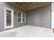 A covered patio area with a door and windows on a gray home exterior at 116 Pointe Park Cir, Holly Springs, NC 27540