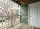 Balcony featuring green siding, white railings, and wooden deck at 1210 Westview Ln # 201, Raleigh, NC 27605