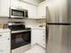 Well-appointed kitchen with stainless steel appliances, white cabinets, and countertops at 1210 Westview Ln # 201, Raleigh, NC 27605