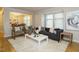 Sunlit living room with hardwood floors, contemporary furniture, and view into dining area at 1210 Westview Ln # 201, Raleigh, NC 27605