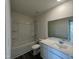 Bathroom with a tub and shower combo, toilet, gray wood-look flooring and a vanity with a white countertop at 128 Oat Grain Ct, Clayton, NC 27520