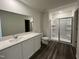 Bathroom with a shower, toilet, gray wood-look flooring and a vanity with a white countertop and a large mirror at 128 Oat Grain Ct, Clayton, NC 27520