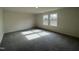 Large bedroom with neutral walls, plush gray carpet, and three windows that provide natural light at 128 Oat Grain Ct, Clayton, NC 27520