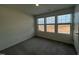 Bright bedroom with neutral walls, plush gray carpeting, and three windows that provide natural light at 128 Oat Grain Ct, Clayton, NC 27520