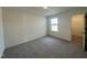 This bedroom has neutral walls, plush gray carpet, and a doorway to a closet with wire racks for clothing at 128 Oat Grain Ct, Clayton, NC 27520