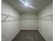 Walk-in closet with wire racks for clothing and shelves, neutral walls, and plush gray carpet at 128 Oat Grain Ct, Clayton, NC 27520