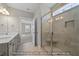 Elegant bathroom featuring a double vanity, tiled walk-in shower with a seat, and natural light at 1811 Parham Dr, Graham, NC 27253