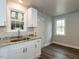 Bright kitchen features white cabinets, granite countertops, and a stainless steel sink at 200 Pace St, Smithfield, NC 27577