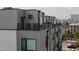 Modern condo building with rooftop terrace, gray siding, and air conditioning units at 2000 Moody Ln, Durham, NC 27701
