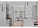 Modern white kitchen and adjacent dining area features stainless steel appliances, quartz counters, and stylish pendant lighting at 2000 Moody Ln, Durham, NC 27701