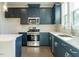 This open kitchen has stainless steel appliances, blue cabinets, and an island with white countertop at 2015 Trident Maple Ln, Chapel Hill, NC 27517