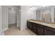 Bathroom featuring granite countertops, double sinks, a large mirror, and access to a walk-in closet at 222 Glenwood Ave # 608, Raleigh, NC 27603