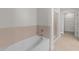 Clean white bathtub with tile surround paired with a glass-enclosed shower in the neutral-toned bathroom at 222 Glenwood Ave # 608, Raleigh, NC 27603