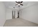 Bright bedroom with neutral carpet, ceiling fan, and access to the kitchen through an open doorway at 222 Glenwood Ave # 608, Raleigh, NC 27603