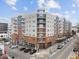 Corner view of multi-story apartment building with brick facade, balconies, and street parking on a sunny day at 222 Glenwood Ave # 608, Raleigh, NC 27603
