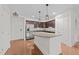 Modern kitchen with stainless steel appliances, granite countertops, wood floors, and island with breakfast bar at 222 Glenwood Ave # 608, Raleigh, NC 27603