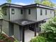 Modern home's exterior featuring gray siding, a flat black roof, and manicured landscaping at 2305 Turners Aly, Raleigh, NC 27607