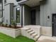 Modern home's front entrance featuring sleek gray siding, concrete steps, and manicured landscaping at 2305 Turners Aly, Raleigh, NC 27607