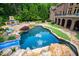 Expansive backyard featuring a custom pool, outdoor fireplace and landscaping at 2421 Acanthus Dr, Wake Forest, NC 27587