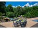 View from the terrace overlooking a well-landscaped backyard with a pool and plenty of surrounding trees at 2421 Acanthus Dr, Wake Forest, NC 27587