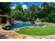 Expansive backyard with a stunning pool, rock features, lush landscaping, and inviting outdoor living spaces at 2421 Acanthus Dr, Wake Forest, NC 27587