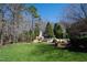Expansive backyard with an outdoor fireplace, seating area, and lush lawn at 2421 Acanthus Dr, Wake Forest, NC 27587