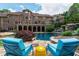 Beautiful pool area with lounge chairs overlooking the expansive brick home and serene waterfall feature at 2421 Acanthus Dr, Wake Forest, NC 27587