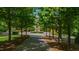 Stately brick home featuring a circular driveway with fountain and manicured landscaping through trees at 2421 Acanthus Dr, Wake Forest, NC 27587