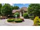 Elegant brick home featuring a circular driveway, fountain, and meticulously maintained landscaping at 2421 Acanthus Dr, Wake Forest, NC 27587