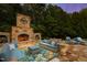 Cozy outdoor living space with a stone fireplace, plush seating, and a beautifully patterned rug at 2421 Acanthus Dr, Wake Forest, NC 27587