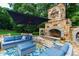 Inviting outdoor space featuring a stone fireplace, comfortable seating, and a vibrant floral rug at 2421 Acanthus Dr, Wake Forest, NC 27587