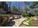 Outdoor kitchen features stone accents, stainless steel grill, and lush landscaping for entertaining at 2421 Acanthus Dr, Wake Forest, NC 27587