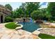 Backyard oasis showcasing a sparkling pool with a slide, rock features, and meticulously maintained landscaping at 2421 Acanthus Dr, Wake Forest, NC 27587