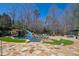 Backyard pool featuring a grotto, water slide, lush landscaping, and stone patio at 2421 Acanthus Dr, Wake Forest, NC 27587