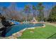 Backyard oasis featuring a luxurious pool, waterfall, slide, and a cozy outdoor kitchen area at 2421 Acanthus Dr, Wake Forest, NC 27587