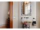 Elegant powder room featuring a decorative mirror, vessel sink, and ornate fixtures at 2421 Acanthus Dr, Wake Forest, NC 27587