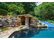 Magnificent pool area with a rock grotto, slide, and waterfall, surrounded by lush landscaping at 2421 Acanthus Dr, Wake Forest, NC 27587
