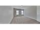 Bedroom featuring two bright windows and plush neutral carpet at 257 Swann Trl, Clayton, NC 27527
