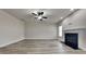 Open living room showcasing a fireplace, ceiling fan, and wood floors at 257 Swann Trl, Clayton, NC 27527